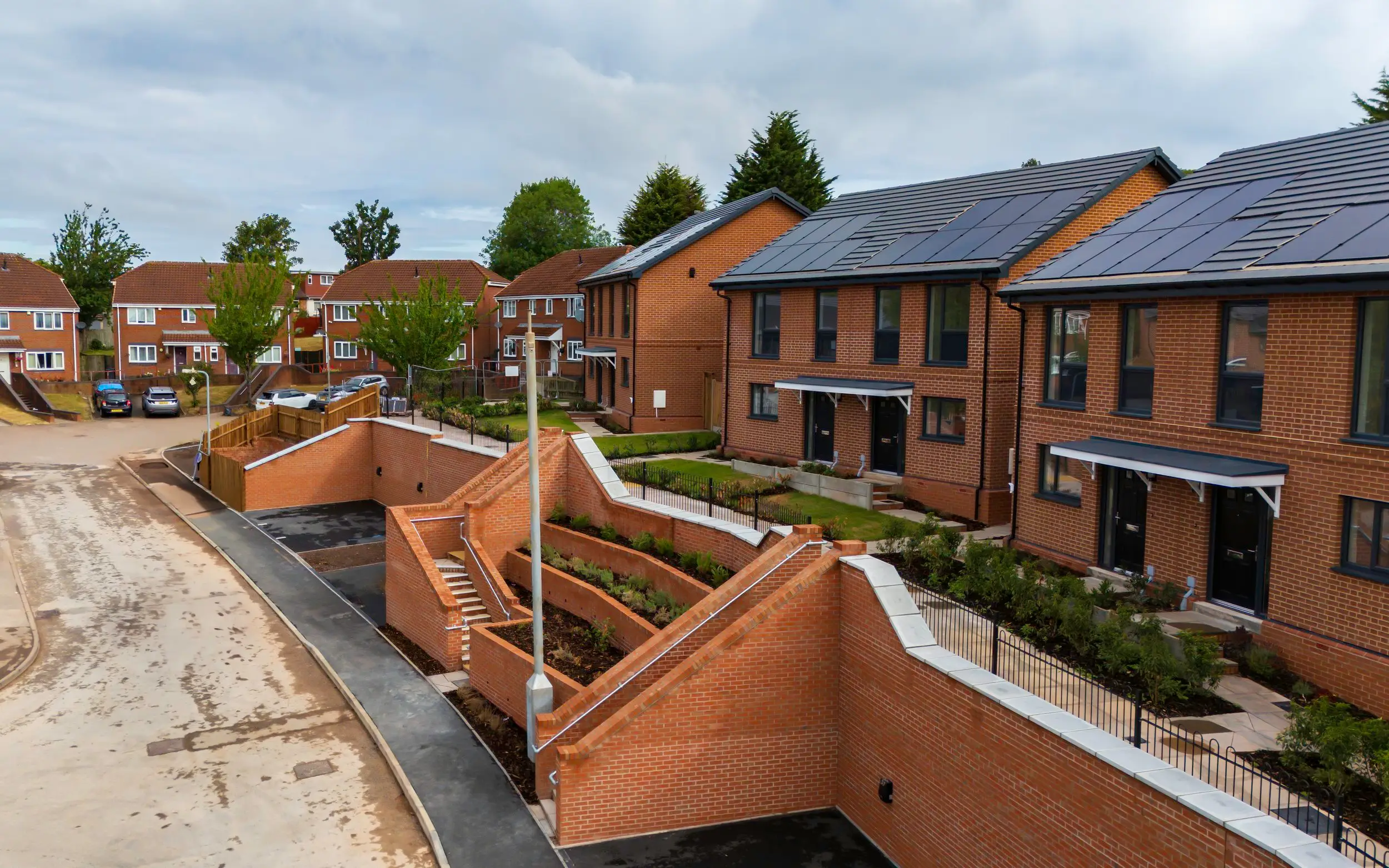 Stepped brick retaining walls and ramped access between the new homes and the street